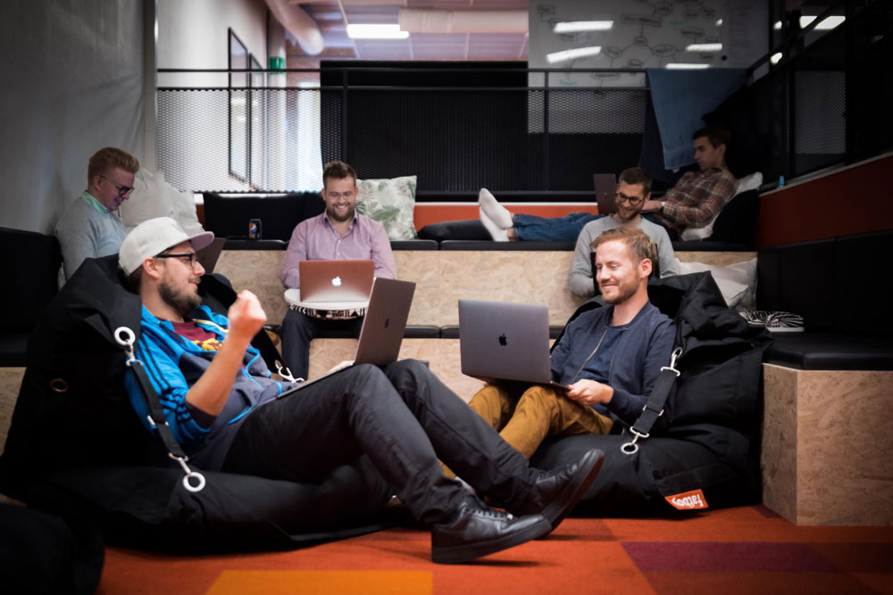 Kollegor som sitter i en hörna av soffor som byggts anpassat för dom